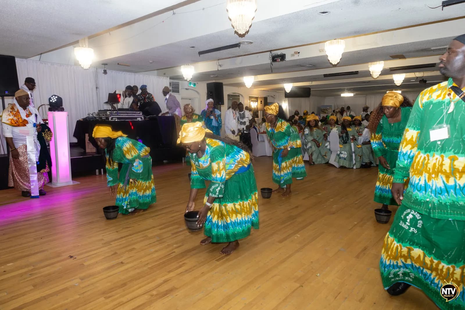 Group performing a collective dance in green attire before the audience at the 2025 Convention.